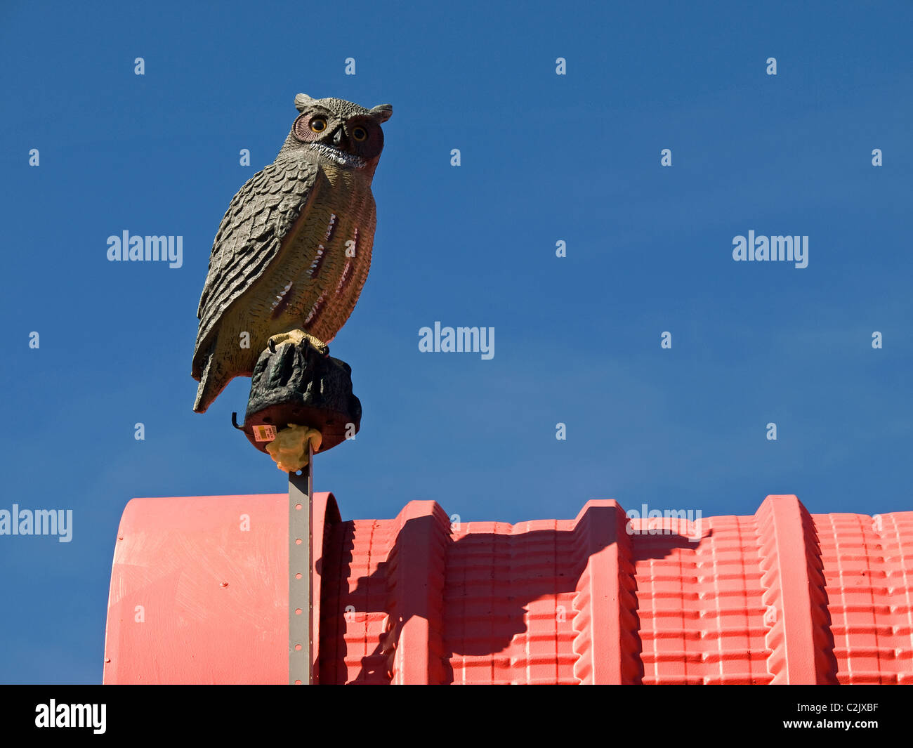 Il gufo fittizia sulla cima di una fabbrica di costruzione per spaventare pest uccelli come gabbiani e piccioni Foto Stock