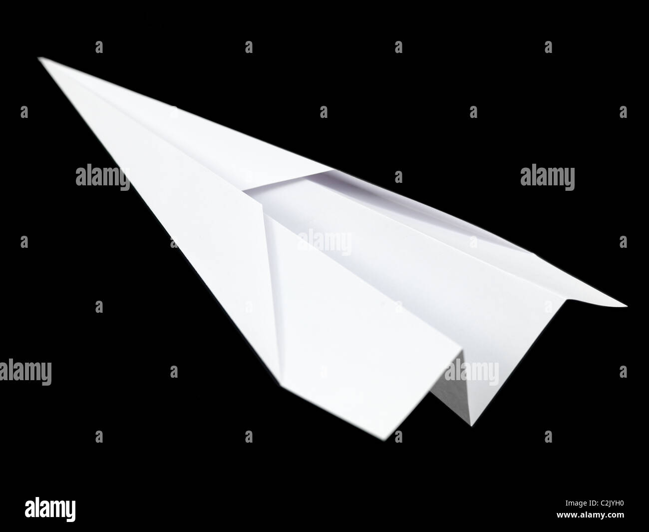 Un aeroplano di carta isolata contro uno sfondo nero Foto Stock