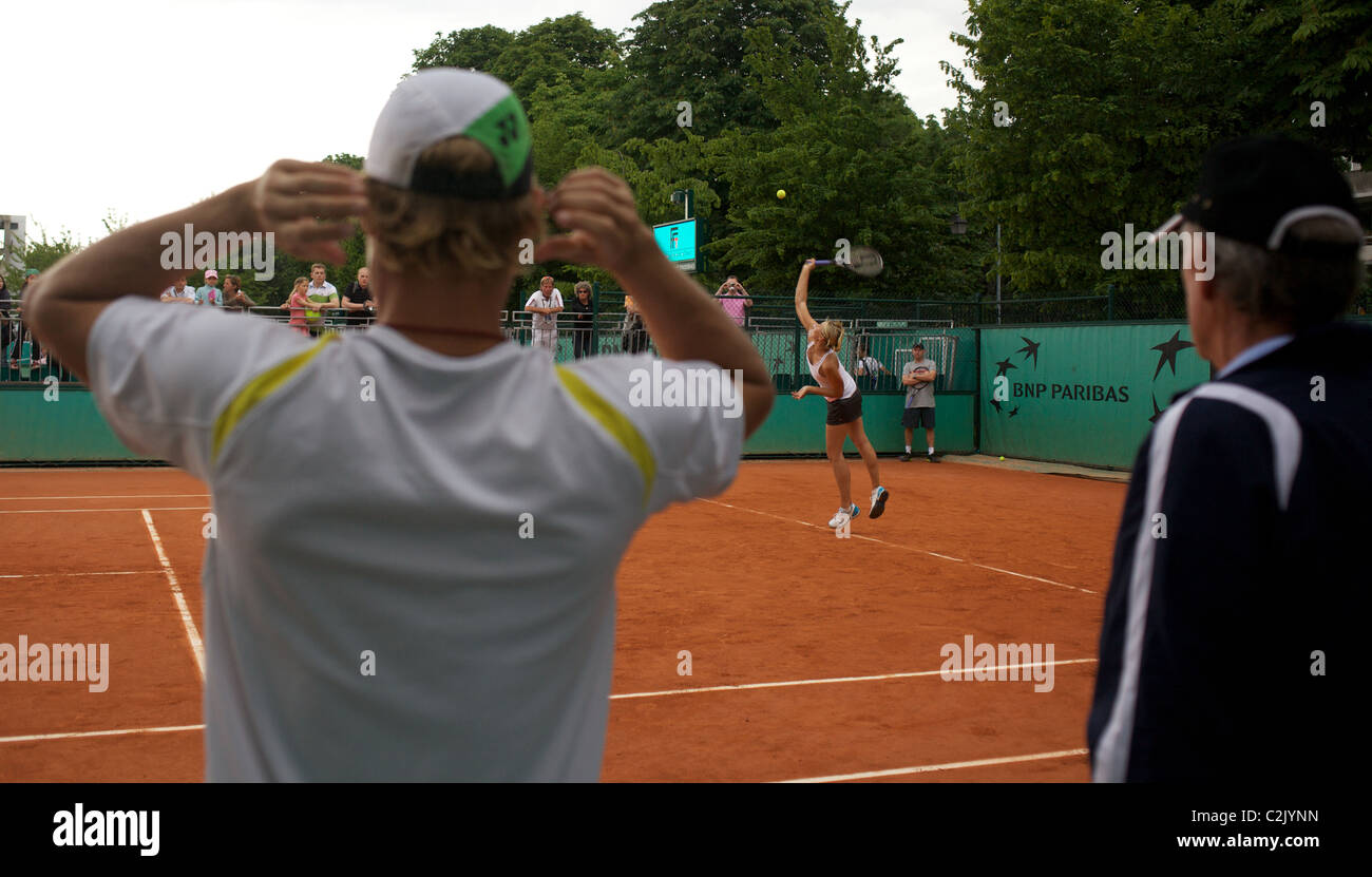 Maria Sharapova formazione guardato da Lleyton Hewitt e Tony Roach in attesa che le loro assegnazioni il tempo di formazione al Roland Garros Foto Stock