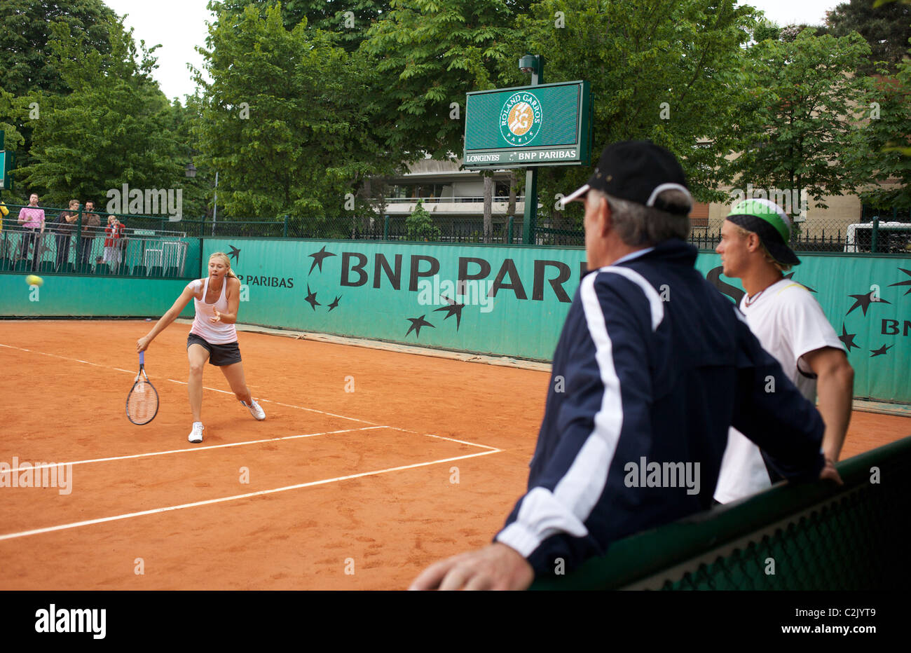 Maria Sharapova formazione guardato da Lleyton Hewitt e Tony Roach in attesa che le loro assegnazioni il tempo di formazione al Roland Garros Foto Stock