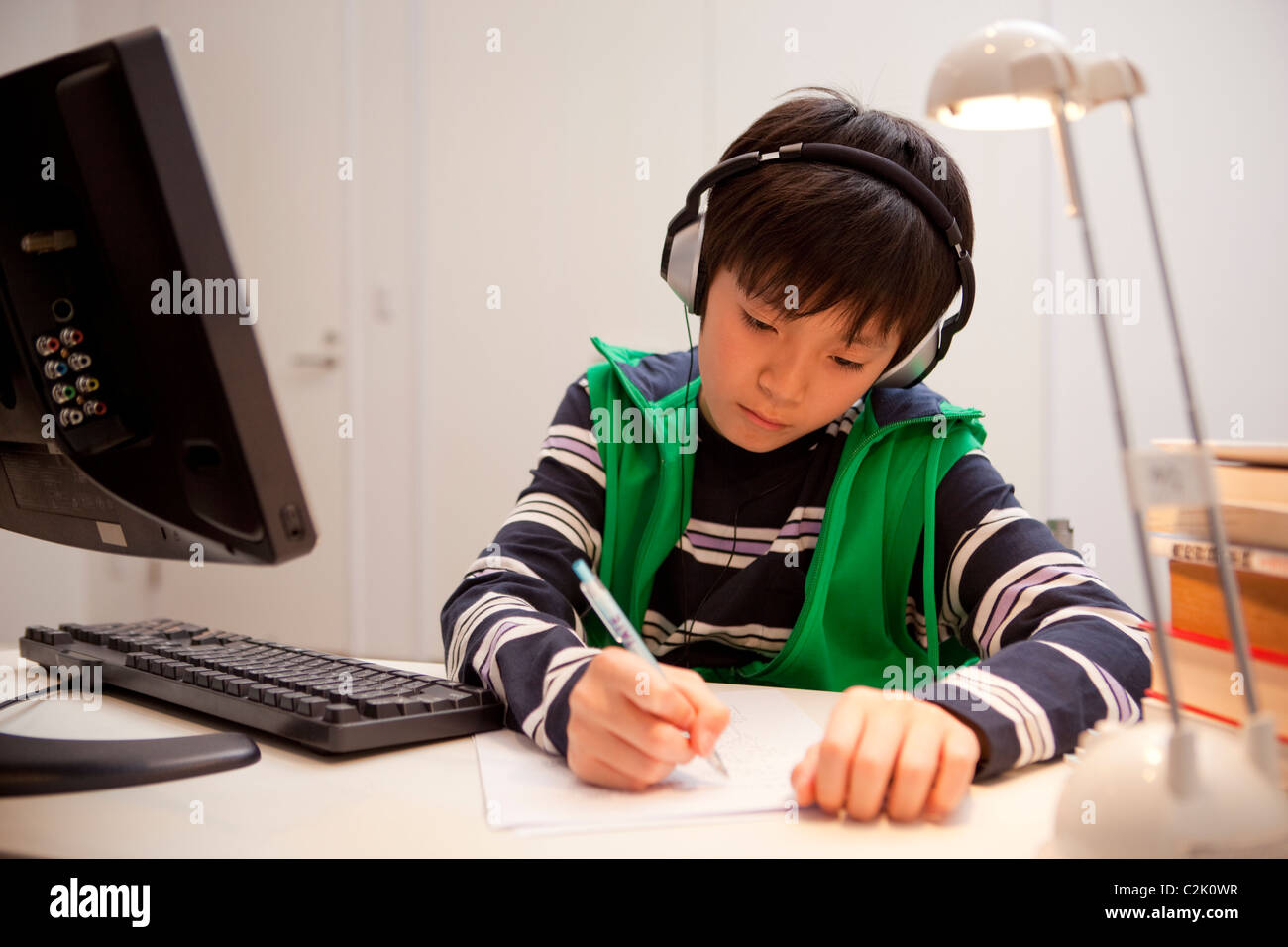 Ragazzo a studiare con le cuffie Foto Stock