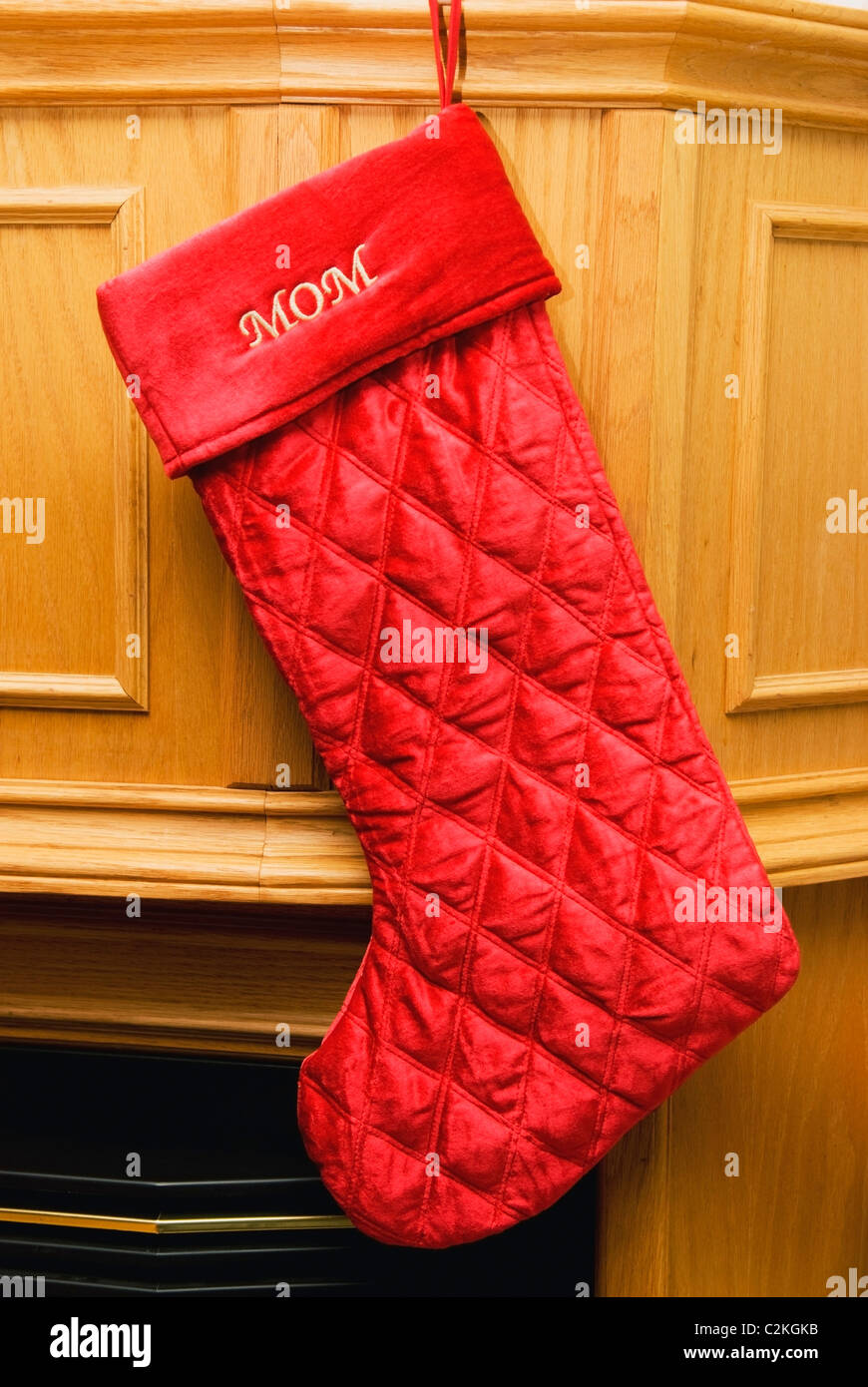 Una calza per Mom appeso accanto al caminetto Foto Stock