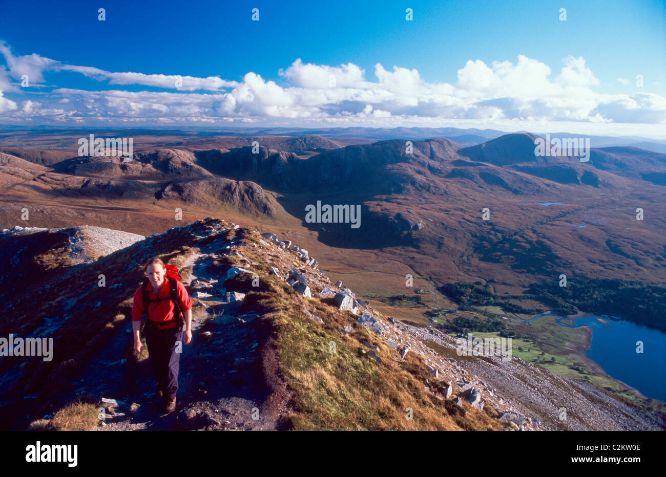 Walker sul vertice di cresta Errigal montagna, con la Derryveagh montagne dietro. Contea di Donegal, Irlanda. Foto Stock