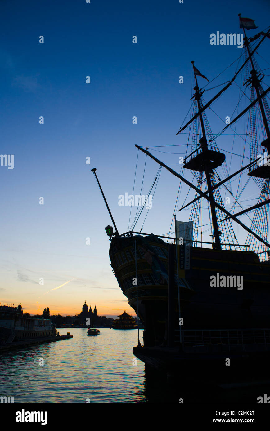 VOC replica della nave 'Amsterdam' all'Amsterdam Museo Marittimo, con tramonto sulla skyline di Amsterdam in background Foto Stock