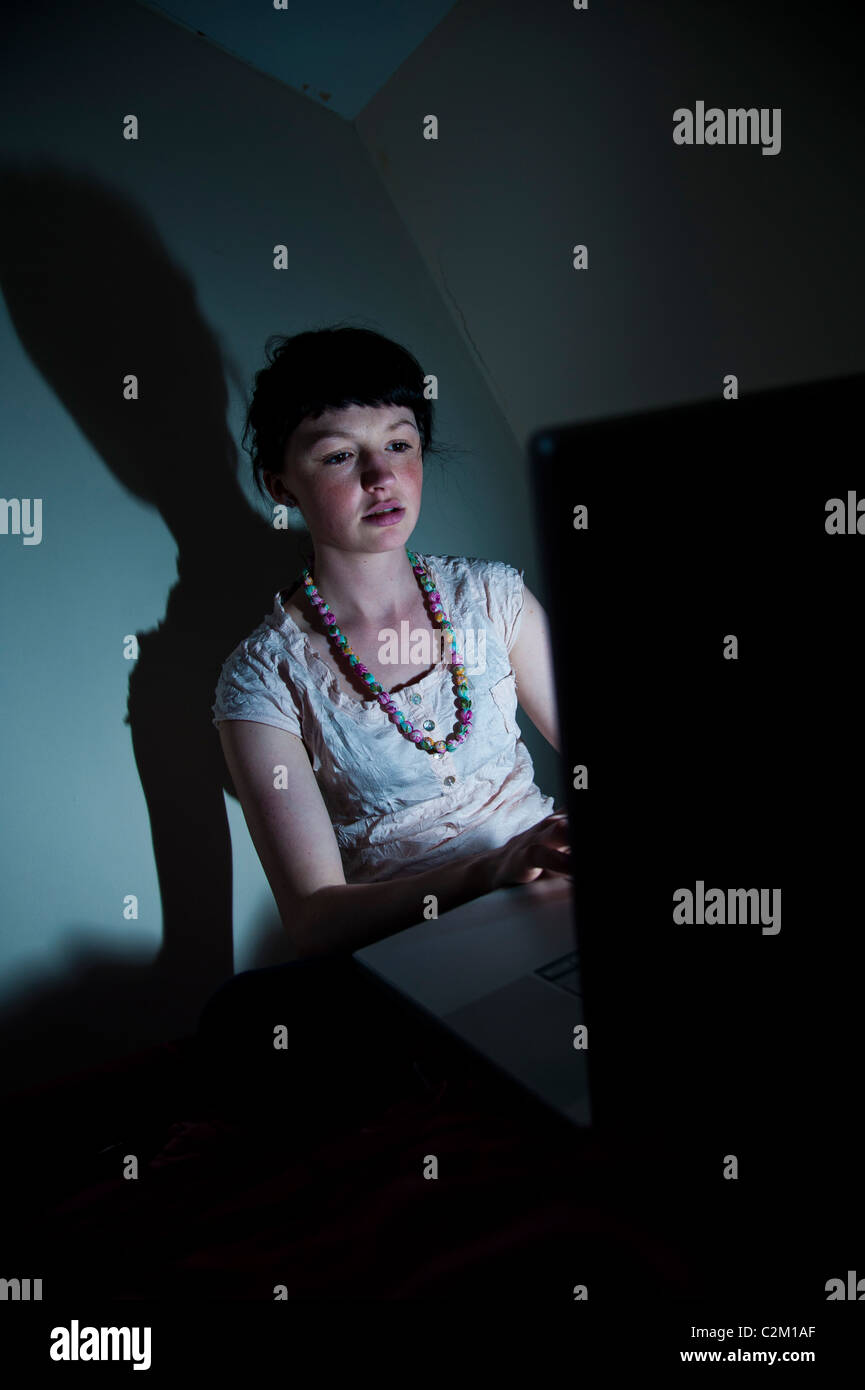 Una giovane donna ragazza UK università studenti che lavorano sul suo computer portatile nella sua camera da letto a casa facebook internet di posta elettronica Foto Stock