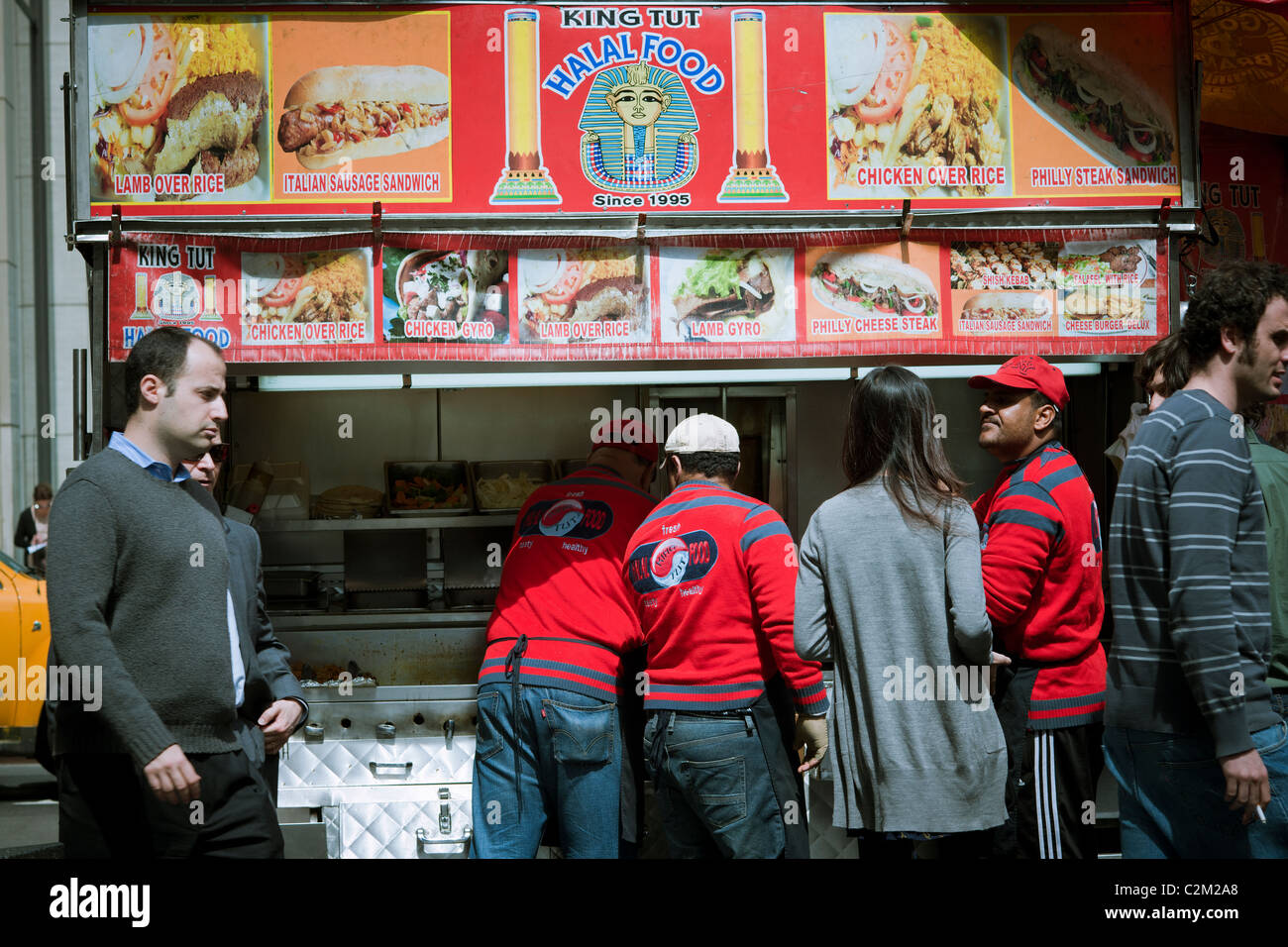 Diners line up per mediorientale il cibo di strada al King Tut carrello sulla sesta Avenue in New York Foto Stock