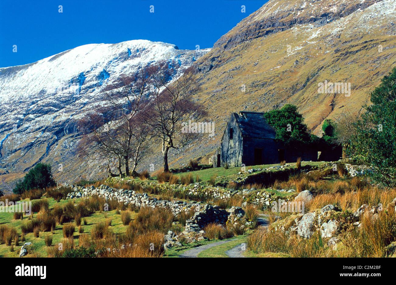 Cottage abbandonati e via in Black Valley, nella contea di Kerry, Irlanda. Foto Stock