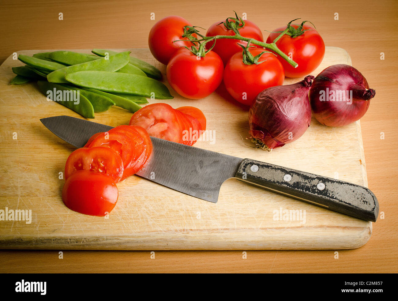 Un mazzetto di verdure fresche su un tagliere di legno Foto Stock
