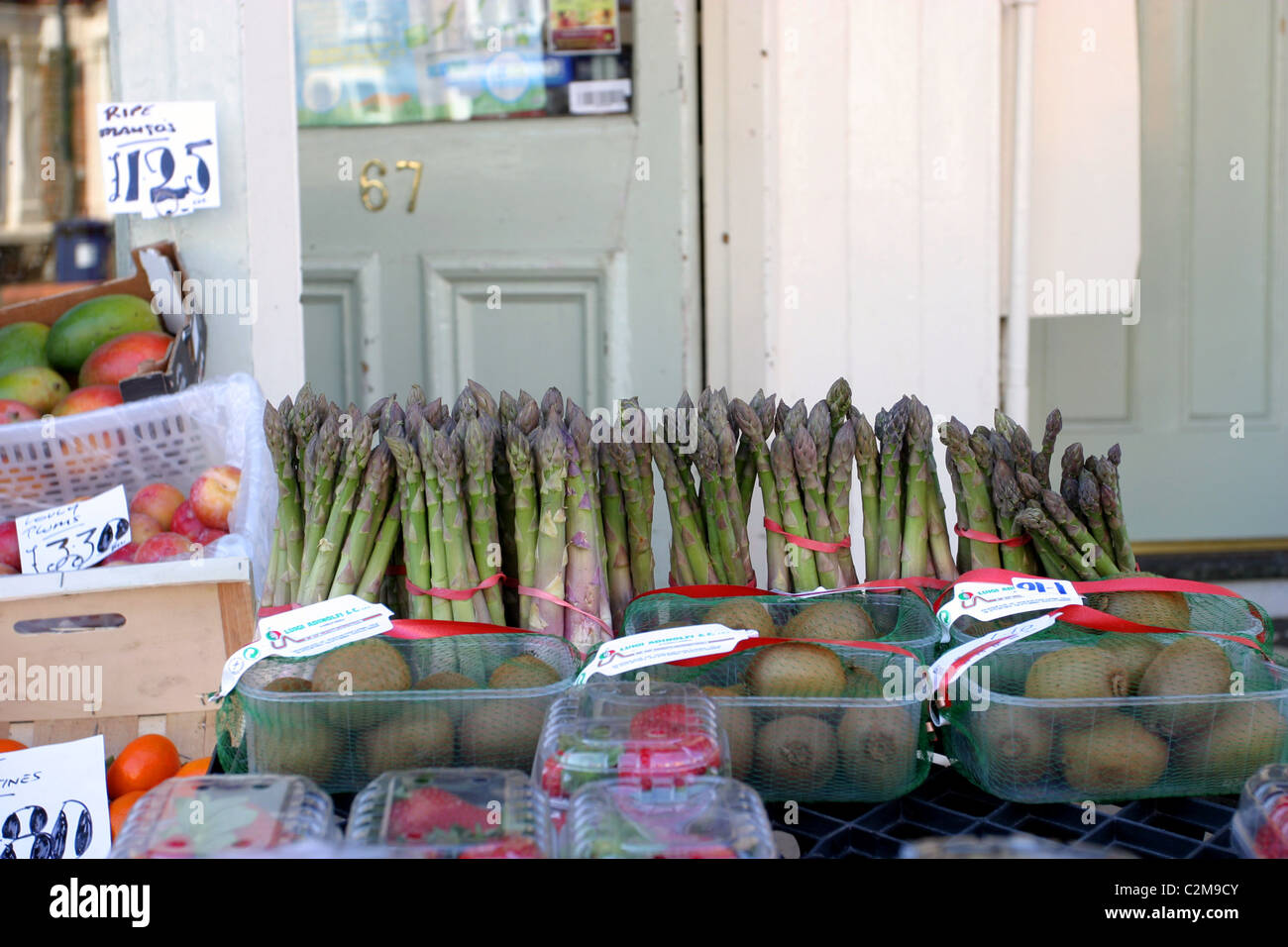 Frutta e verdura visualizzati al di fuori di un locale negozio ad angolo Foto Stock