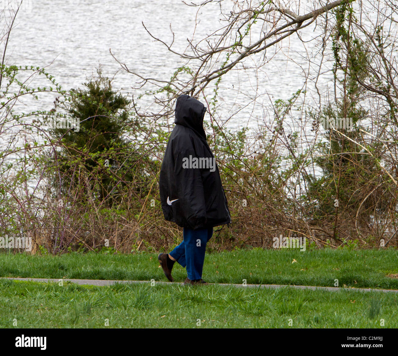 Una donna lady persona in un buio troppo grande giacca con cappuccio. Foto Stock