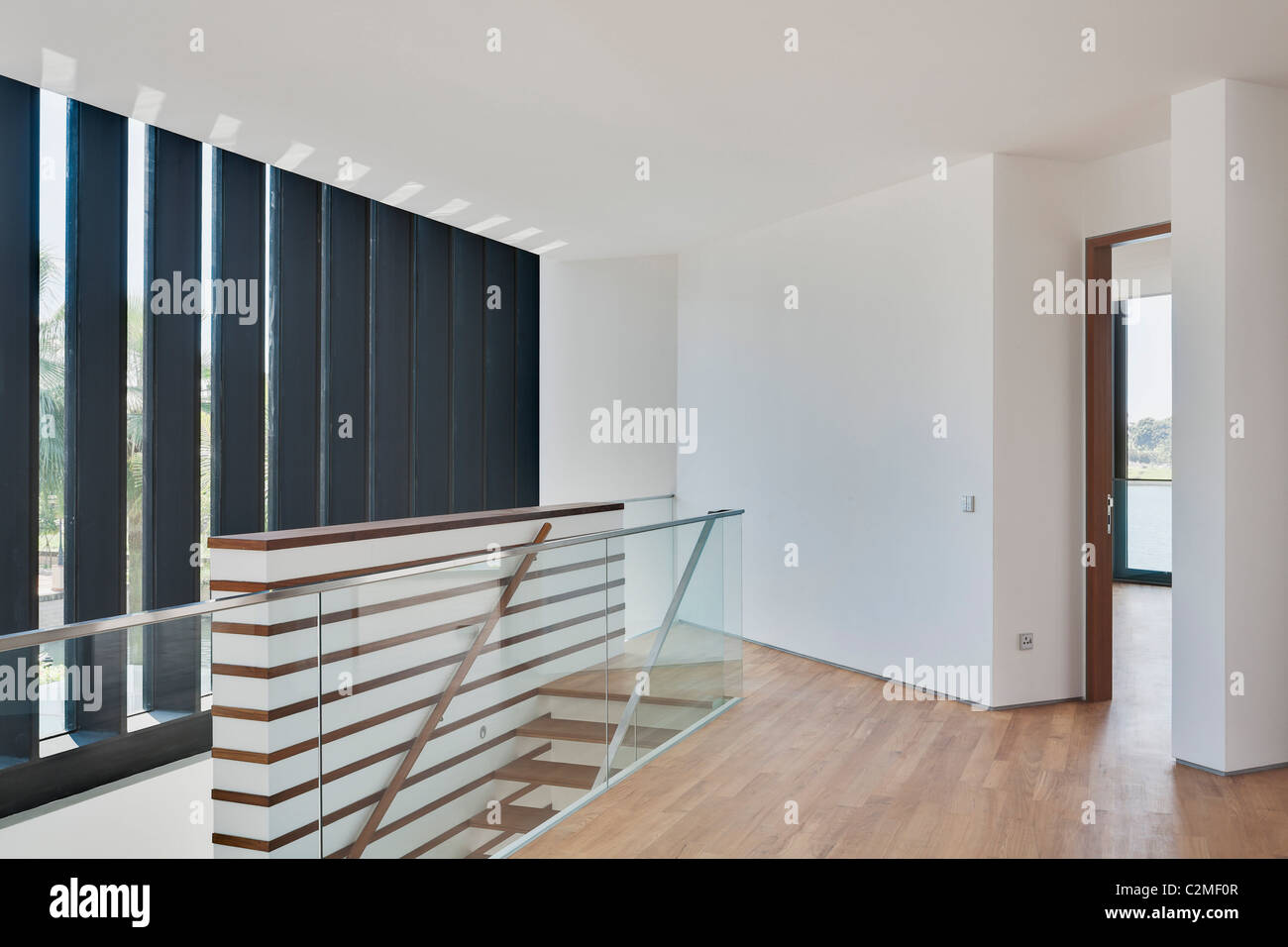 Moderno bianco di atterraggio in cima alle scale con pavimento in legno e aprire lo sportello Foto Stock