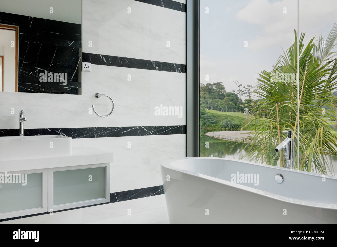 Marmo e pareti di vetro in un bagno moderno con vista sul campo da golf Foto Stock