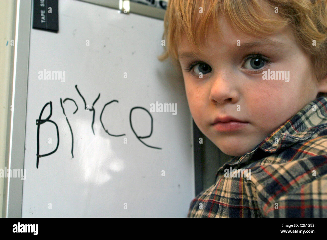 5 anno vecchio ragazzo di scrivere il suo nome sulla lavagna in cucina. Foto Stock
