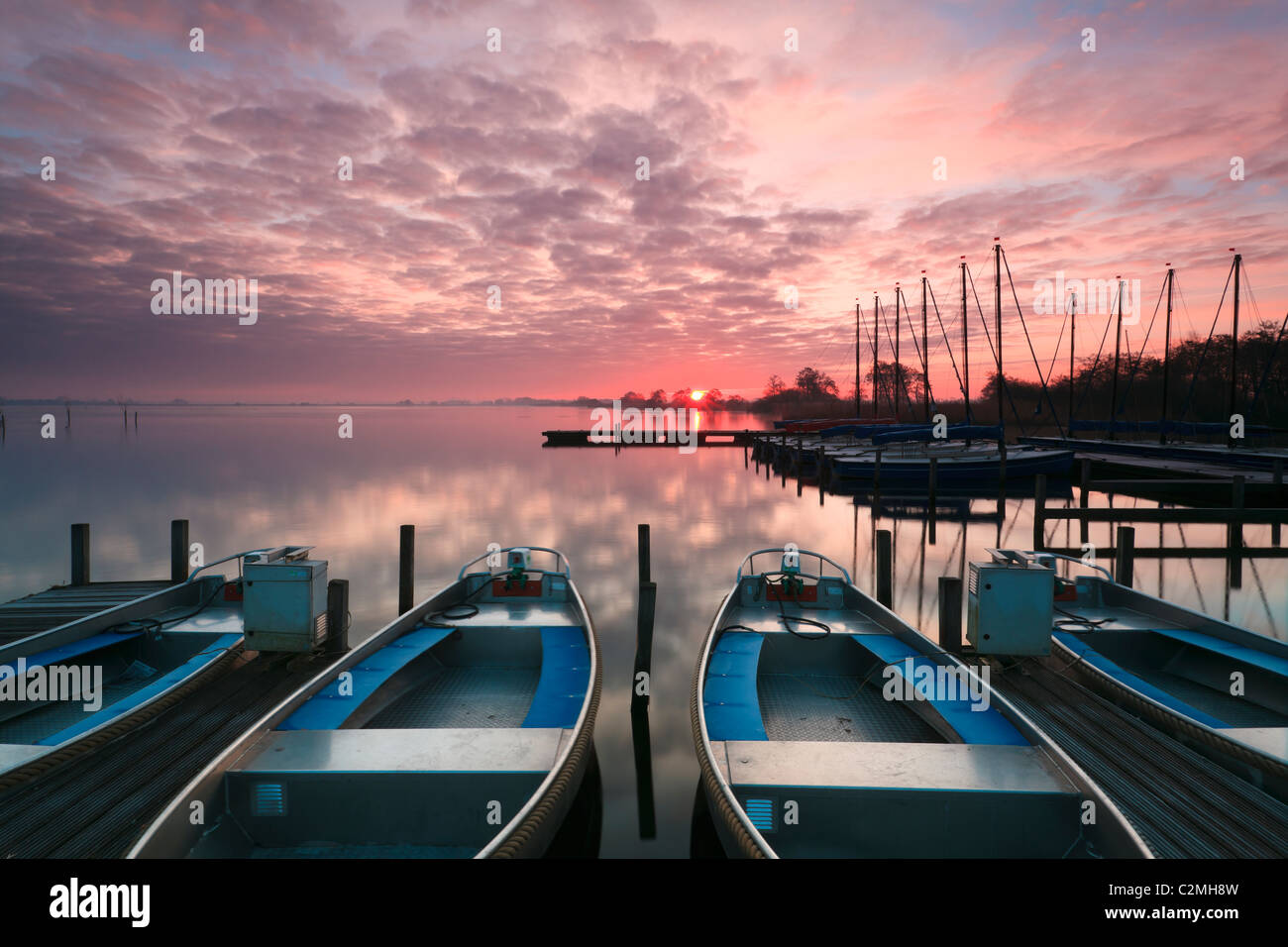 Barche in un porto di un tranquillo sunrise Foto Stock