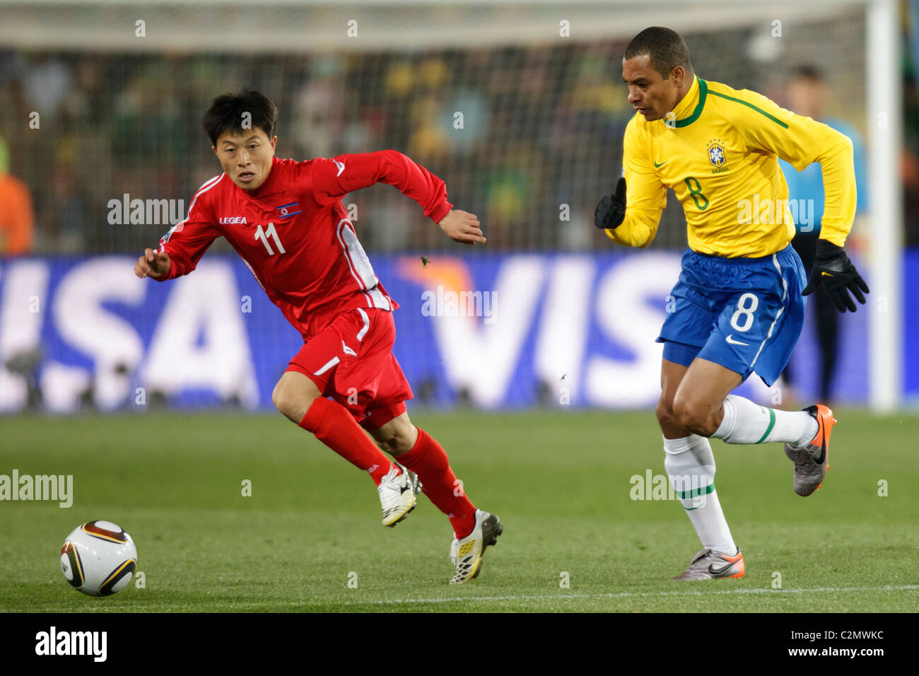 In Guk Mun della Corea del Nord (11) controlla la sfera contro Gilberto Silva del Brasile (8) durante la Coppa del Mondo FIFA 2010 Gruppo G corrispondono Foto Stock