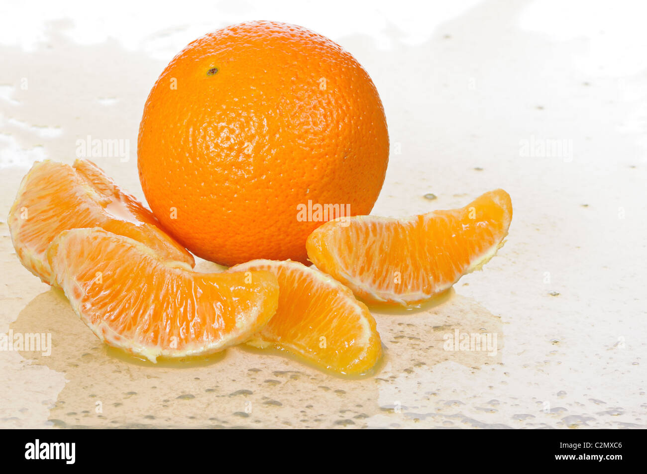 Tutta arancione con segmenti stabilisce in succo di frutta Foto Stock