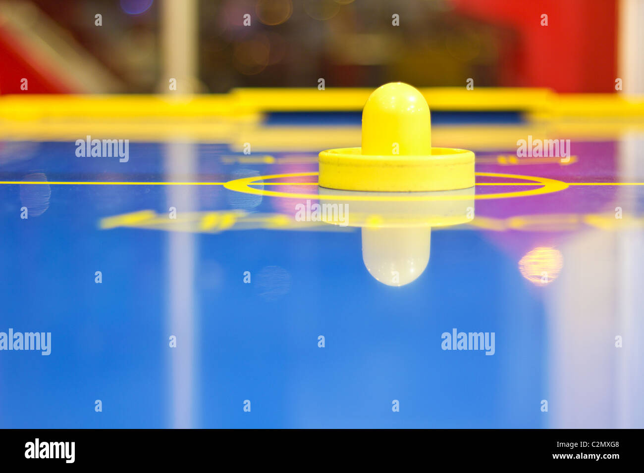 Giallo air hockey mallet su un blu un air-hockey tabella Foto Stock