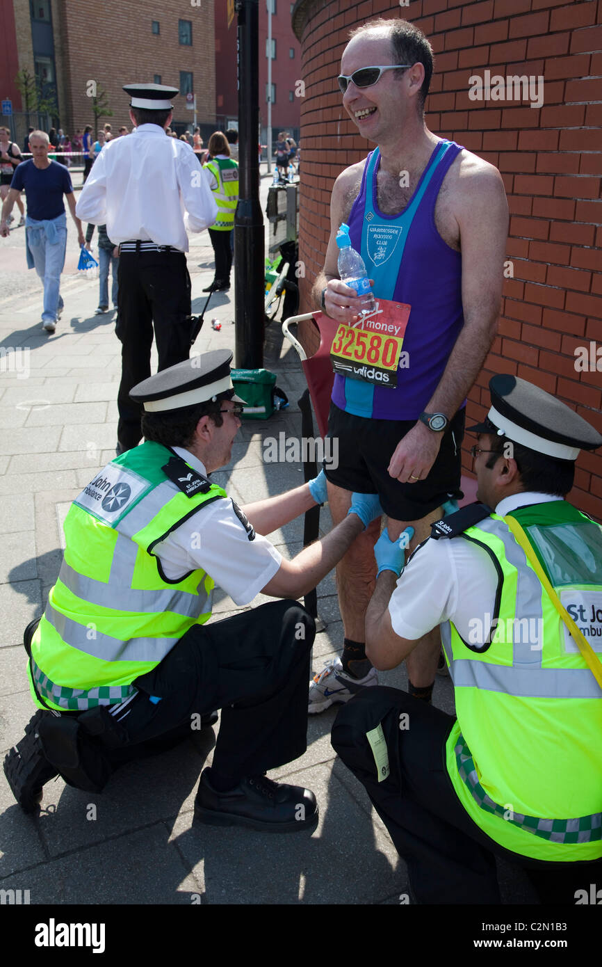 San Giovanni ambulanza dare prima un aiuto a favore di un runner alla maratona di Londra 2011 Foto Stock