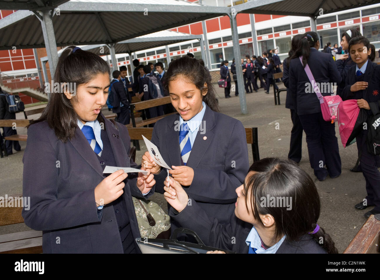 Le ragazze di razza mista e di religione nel parco giochi di una scuola del Regno Unito durante una pausa dalle lezioni. Foto Stock