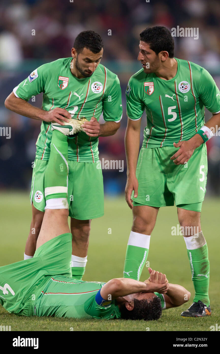 Algeria i giocatori Nadir Belhadj (3) e Rafik Halliche (5) assistere il compagno di squadra antera Yahia (4) in un 2010 World Cup match contro gli USA. Foto Stock
