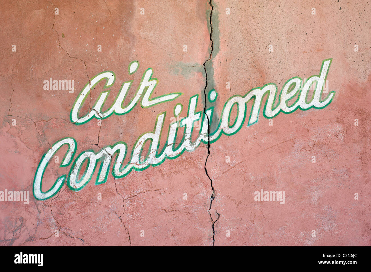 Segno sul vecchio muro Adobe annuncia cool indoor comfort; una tregua dal deserto di calore in Carrizozo, Nuovo Messico. Foto Stock