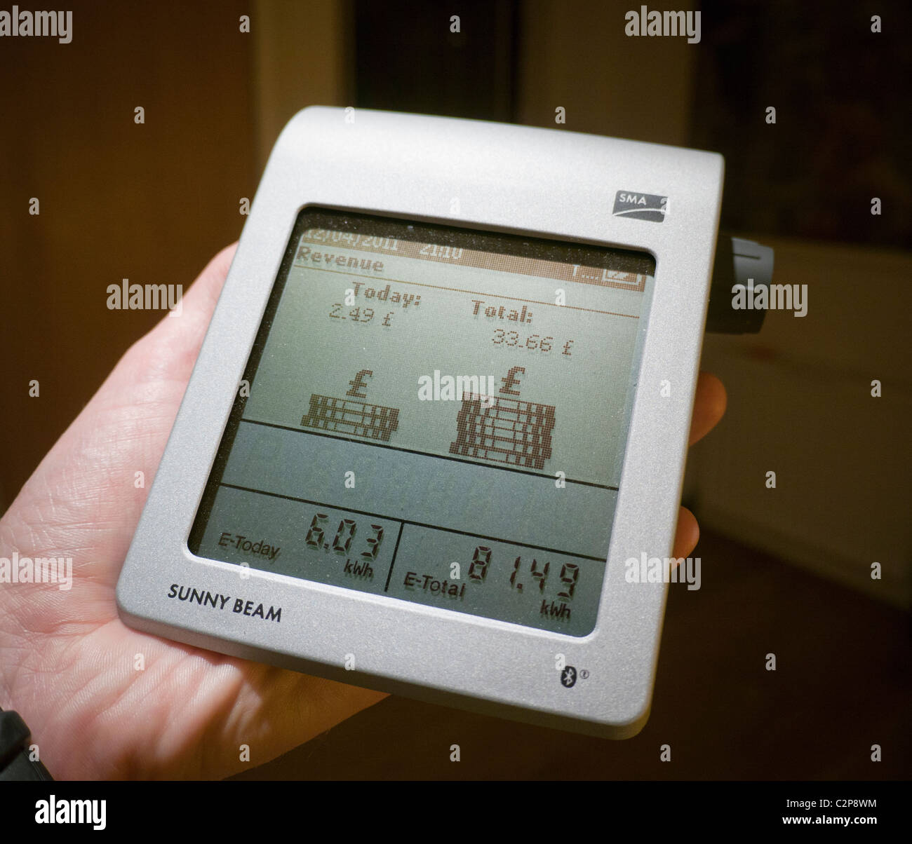 Una mano misuratore wireless che mostra le entrate da una giornata di sole per il feed-in tariffa di un utilizzatore di elettricità nel Regno Unito Foto Stock