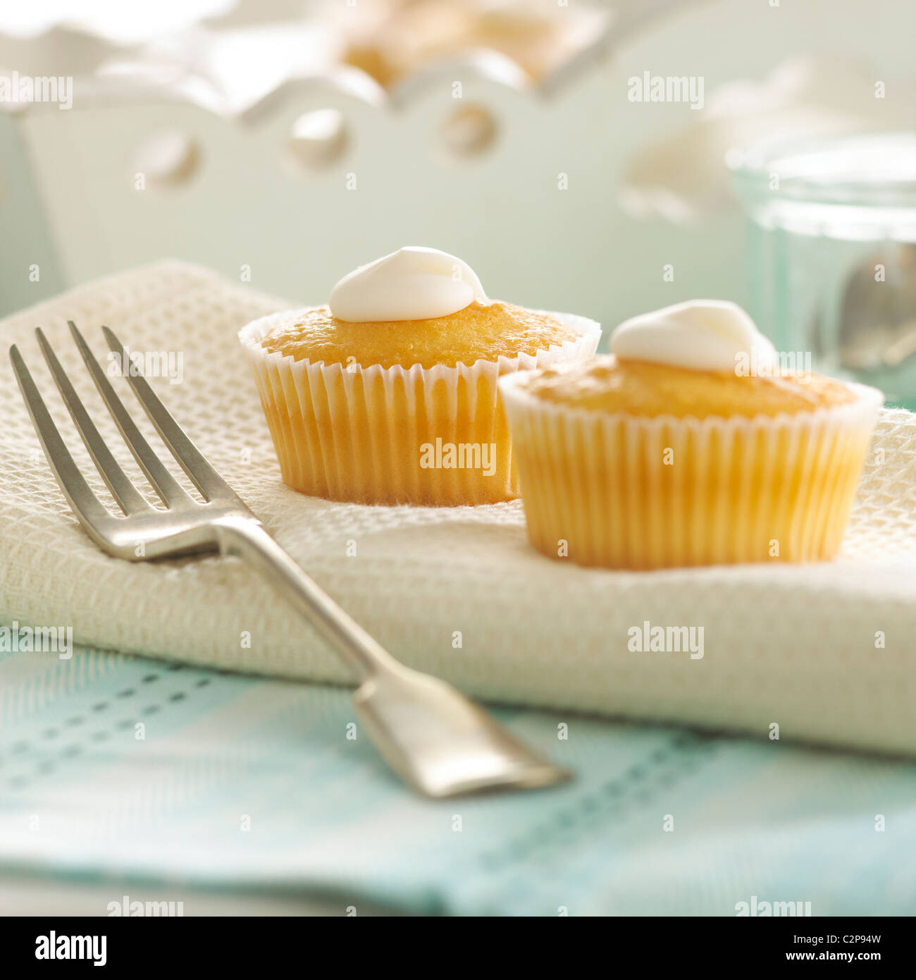 Due tortine con glassa bianca con forcella in casa scena di cottura. Luminosa immagine della scena contemporanea. Impostazione iniziale Foto Stock