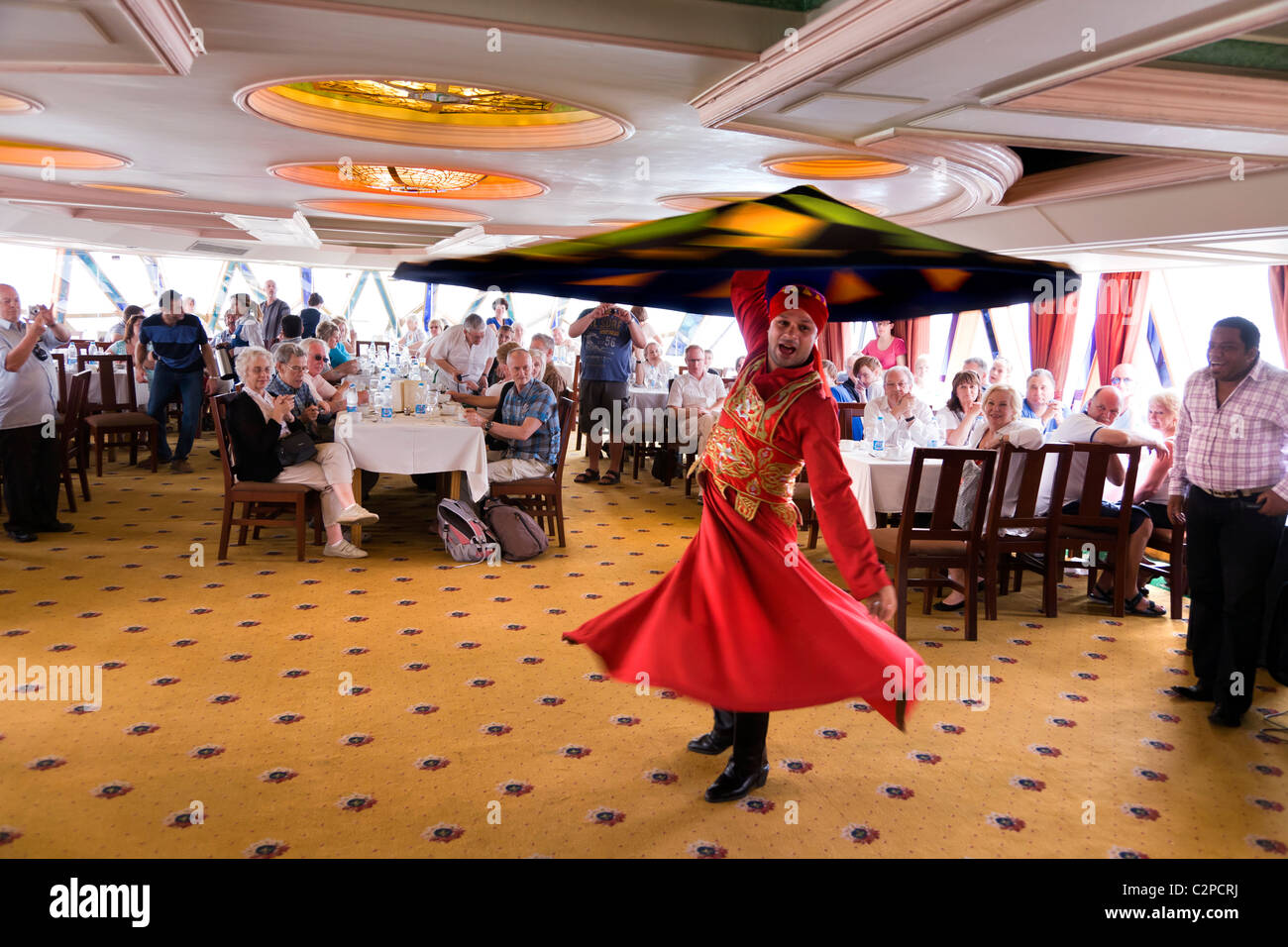 Un derviscio armato intrattenere i turisti su un fiume Nilo in barca, Foto Stock