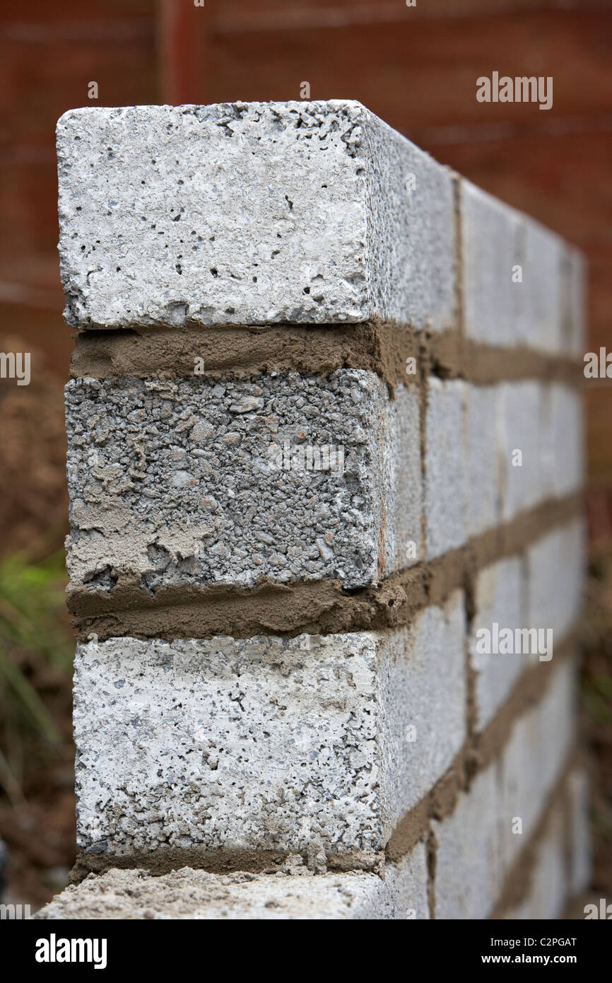 Nuova posa muratura muro con mezza brezza di cemento blocca la costruzione di un blocco di parete di ritegno nel Regno Unito Foto Stock