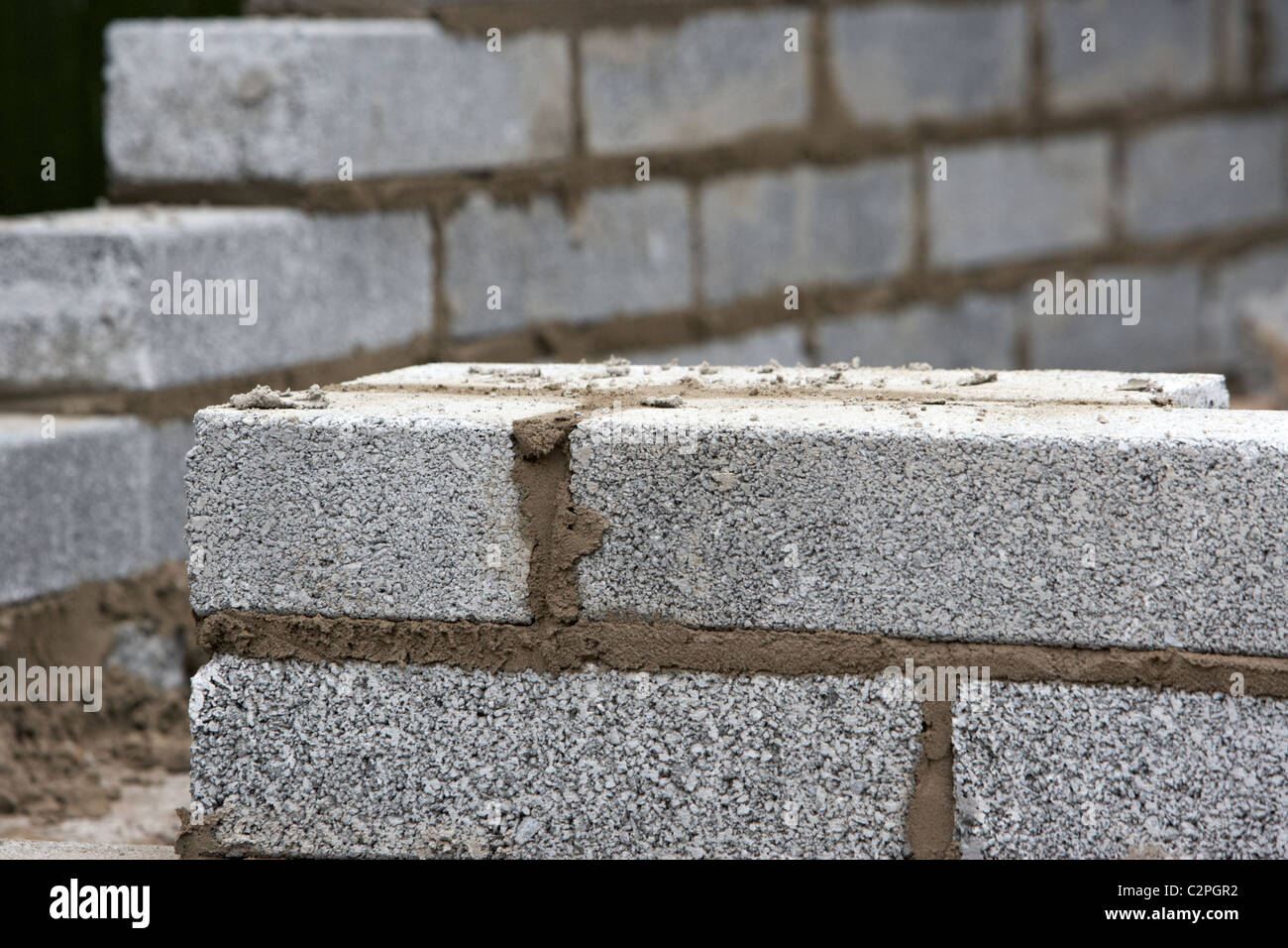 Parzialmente costruita con il muro di cemento a metà breeze blocca la costruzione di un blocco di parete di ritegno nel Regno Unito Foto Stock