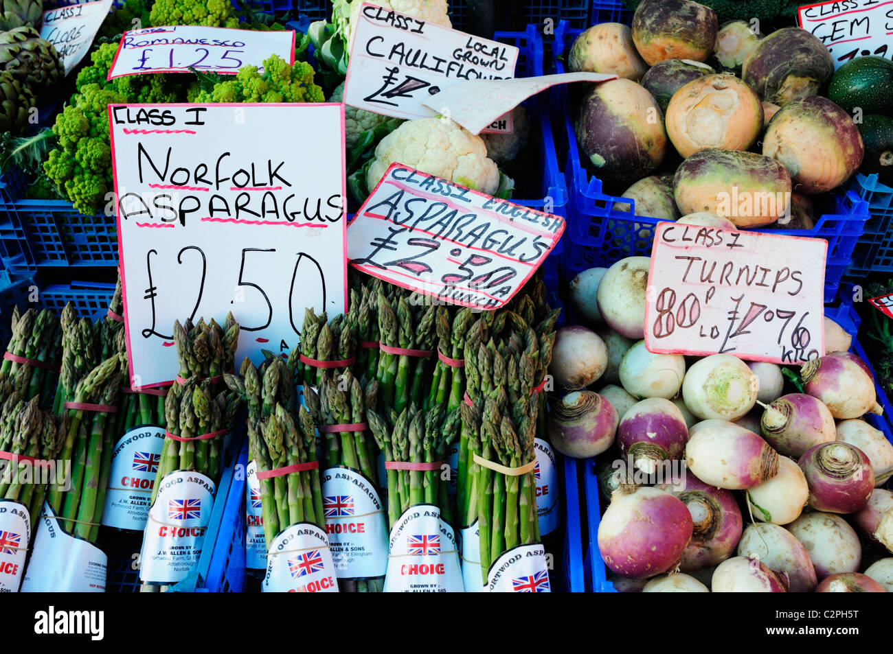 Pressione di stallo di verdure con asparagi e navoni sul mercato, Cambridge, Inghilterra, Regno Unito Foto Stock