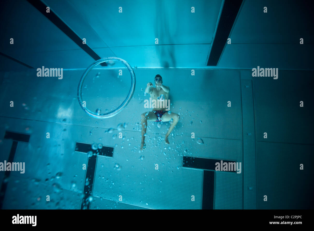 Un nuotatore generando anello di bolla in corrispondenza del fondo di una piscina. Anello di turbolenza, chiamato anche un vortice toroidale. Foto Stock