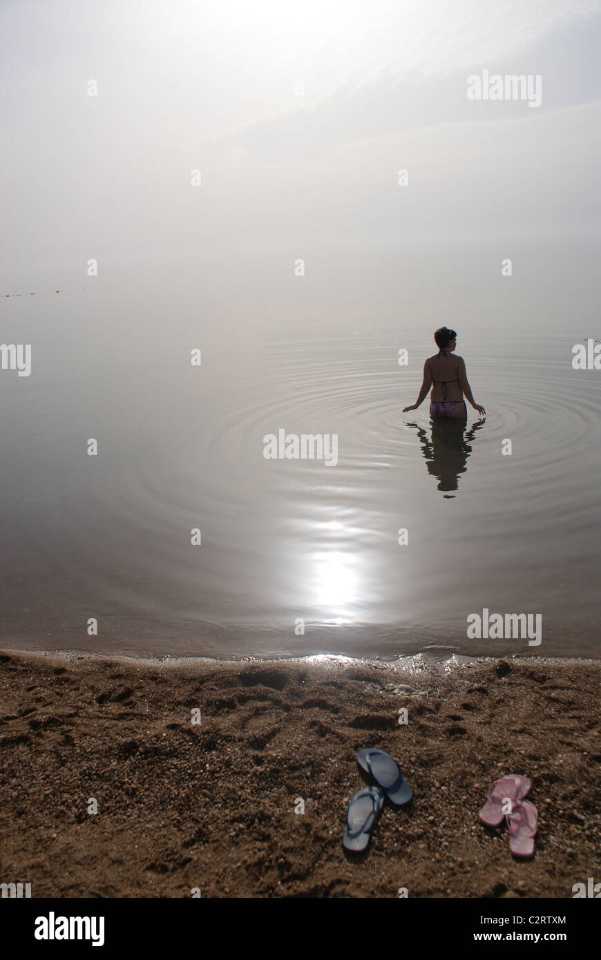 Mar Morto, Giordania: un nuotatore prende in acqua con un Jordanian spa resort. Foto Stock
