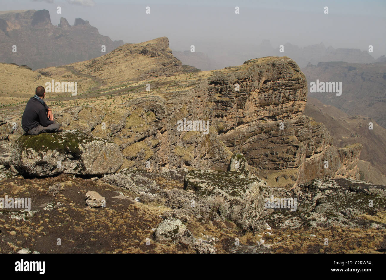 Simien Mountains, l'Etiopia settentrionale: un trekker prende la vista dalla scarpata orlo, sopra Chenek camp. Foto Stock