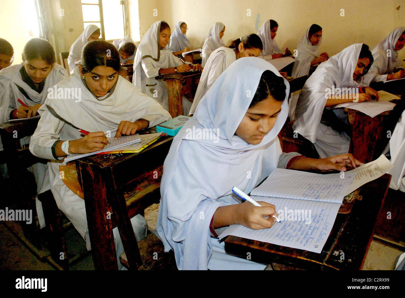Gli studenti a risolvere i fogli a un esame hall durante la matricola annuale esame 2011 Foto Stock