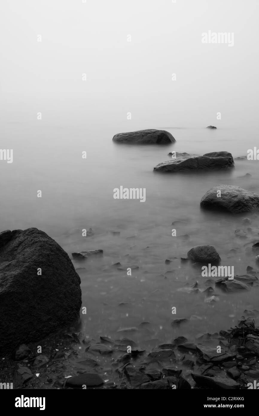 Le pietre si vede in mare coperta di nebbia Foto Stock