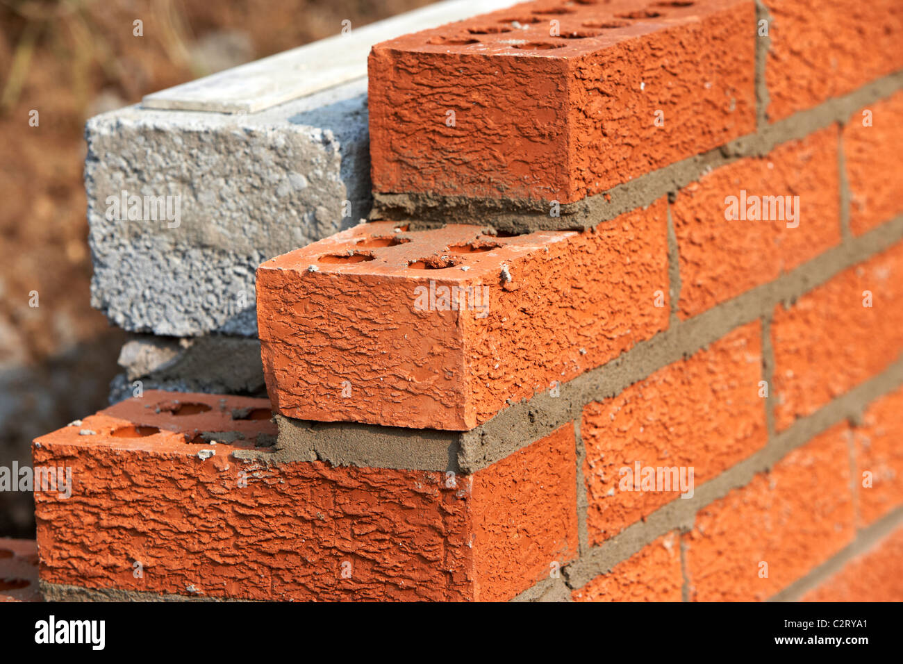 Parete di muratura red house mattoni rivolta verso la metà brezza di cemento blocca la costruzione di un blocco di parete di ritegno nel Regno Unito Foto Stock