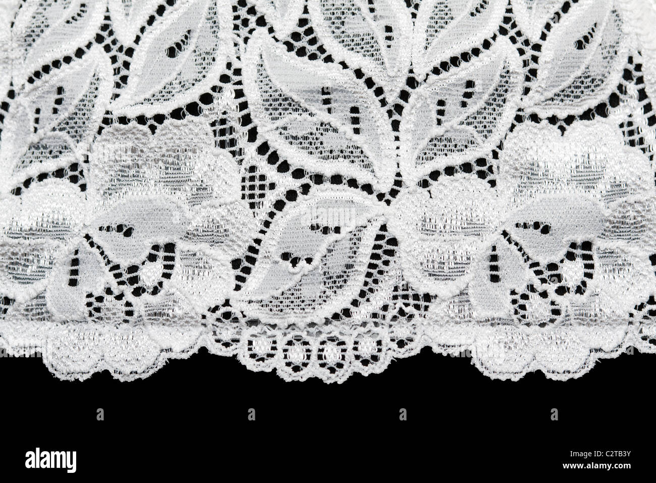 Pizzo Bianco con il pattern con forma fiore su sfondo nero Foto Stock