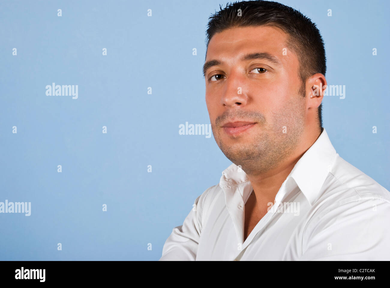 Ritratto di giovane uomo d affari in maglia bianca isolata su sfondo blu,copia di spazio per il testo nella parte sinistra dell'immagine Foto Stock