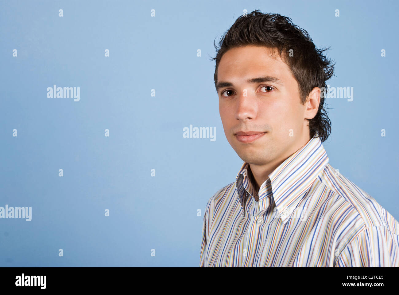 Ritratto di giovane uomo d affari con moderni acconciatura su sfondo blu,copia di spazio per il testo nella parte sinistra dell'immagine Foto Stock