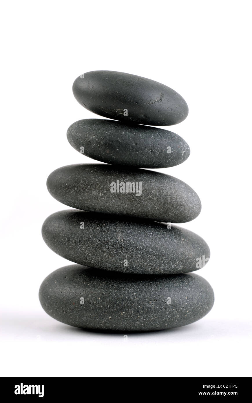 Massaggio Hot Stone Terapia Spa pietre impilate su sulla parte superiore di un altro, isolato su bianco Foto Stock