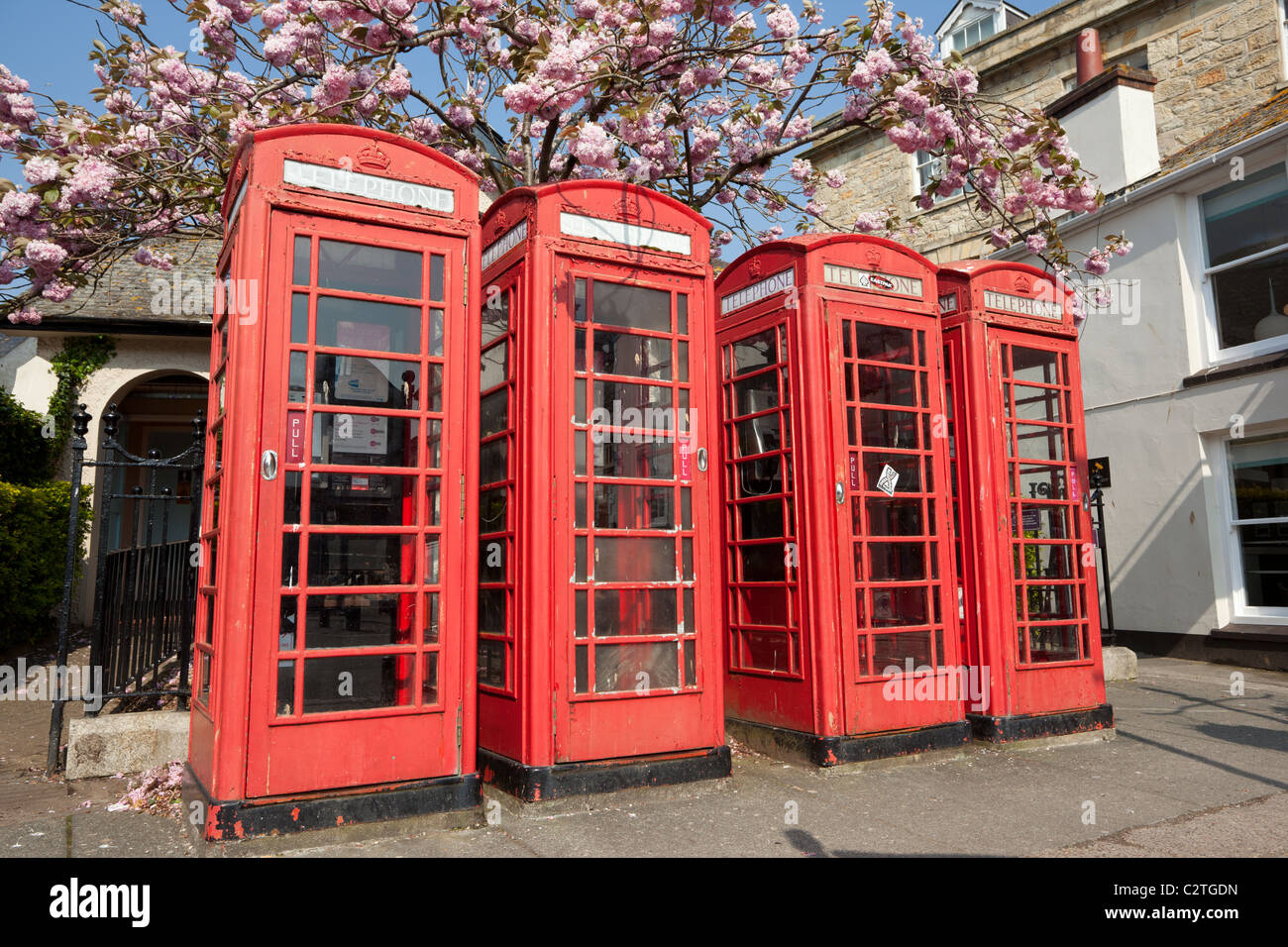 Fila di 4 rosso British telefono scatole in Truro, Cornwall Regno Unito. Foto Stock