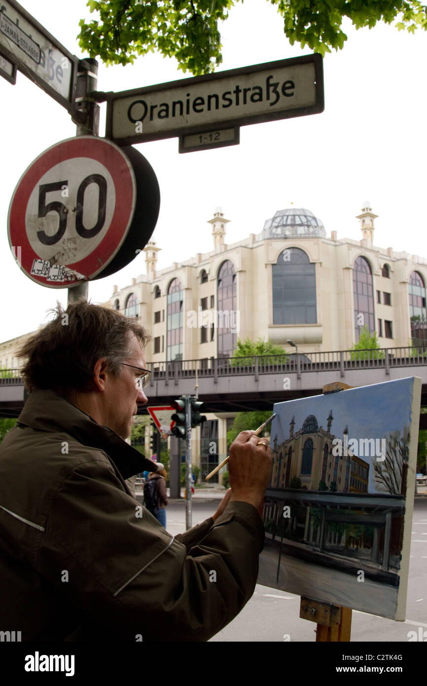 Un uomo adulto dipingere un quadro di un edificio di Oranienstrasse Berlin Foto Stock