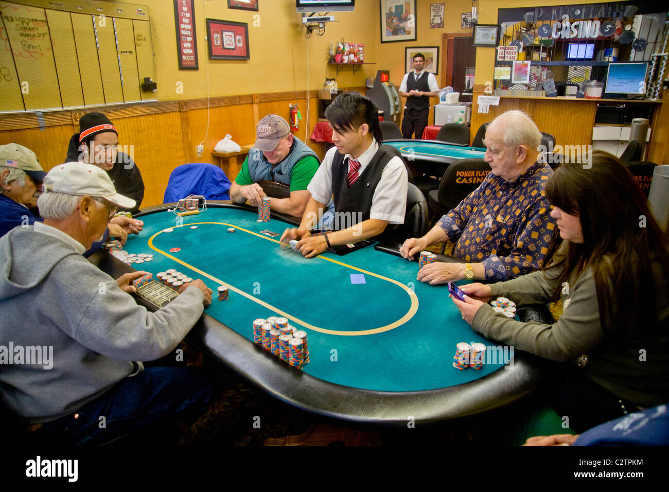 I giocatori di diverse fasce di età e gare di giocare a Texas Hold'em poker presso un negozio di fronte casino di Merced, CA. Foto Stock
