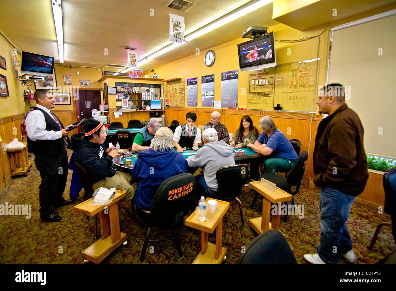 I giocatori di diverse fasce di età e gare di giocare a Texas Hold'em poker presso un negozio di fronte casino di Merced, CA. Foto Stock
