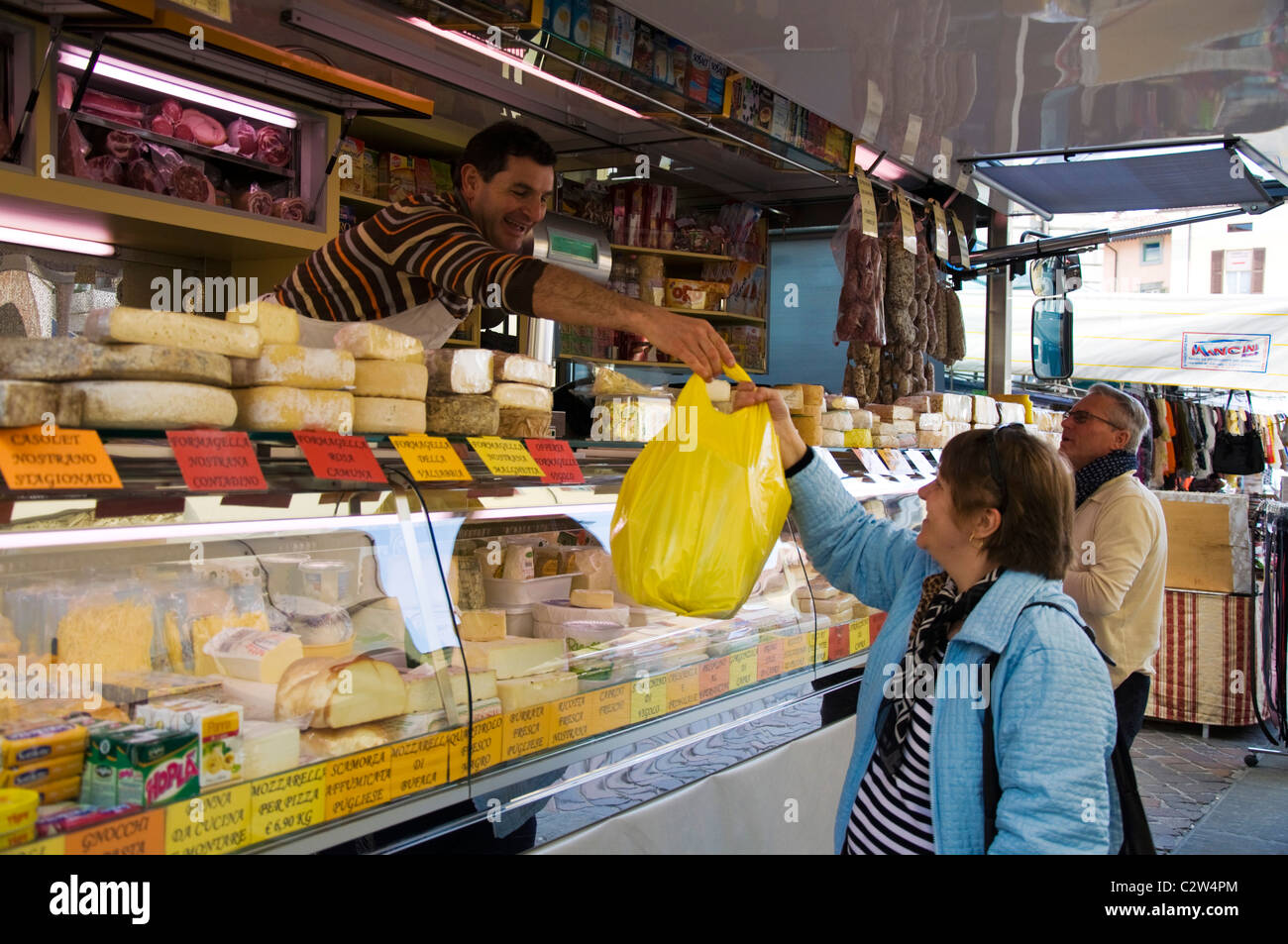 Il cliente in un dispositivo mobile di formaggio e salame a freddo in stallo marketplace in Iseo Foto Stock