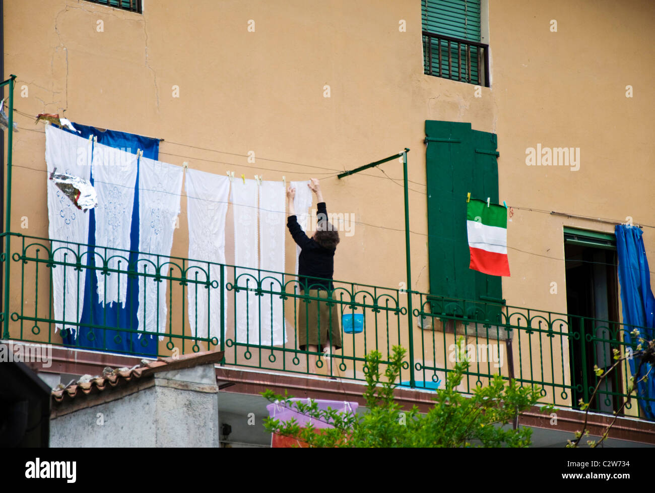 Donna hunging net laccio sulla linea di lavaggio a secco anche una bandiera italiana Foto Stock