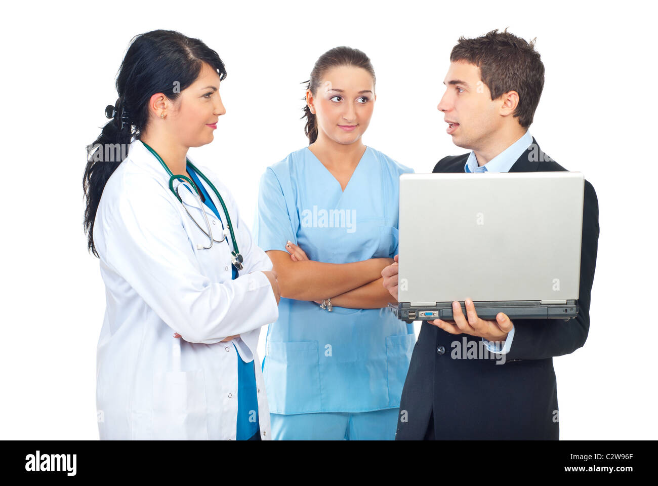 Due medici donne aventi la conversazione con un uomo d affari con computer portatile isolato su sfondo bianco Foto Stock