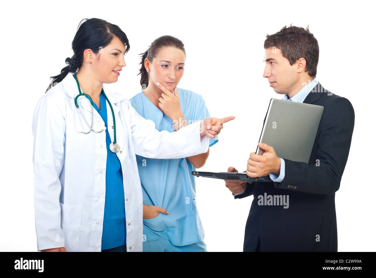 Due medici donne aventi la discussione con un uomo d affari con computer portatile e puntando a scopo isolati su sfondo bianco Foto Stock
