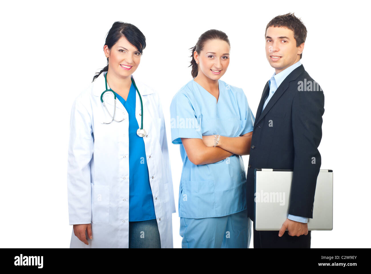 Due medici donne e un uomo d affari con computer portatile in piedi in una fila e sorridente isolati su sfondo bianco Foto Stock